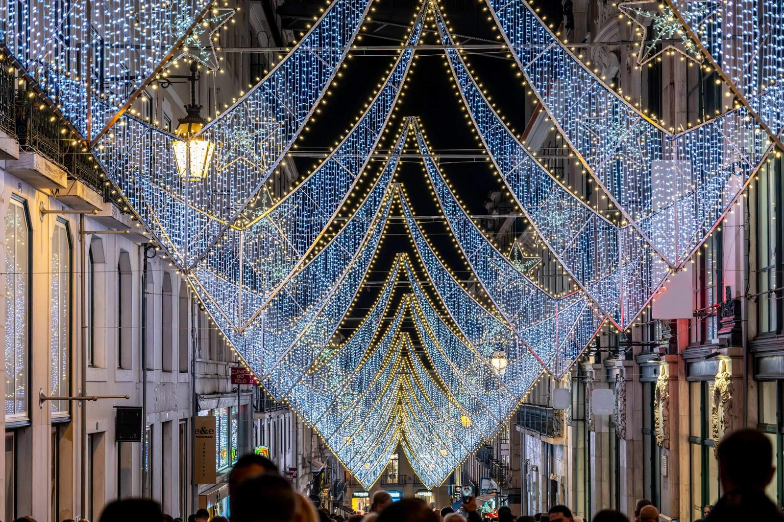 [Translate to English:] Iluminações de Natal no centro da cidade de Lisboa com pessoas a olhar
