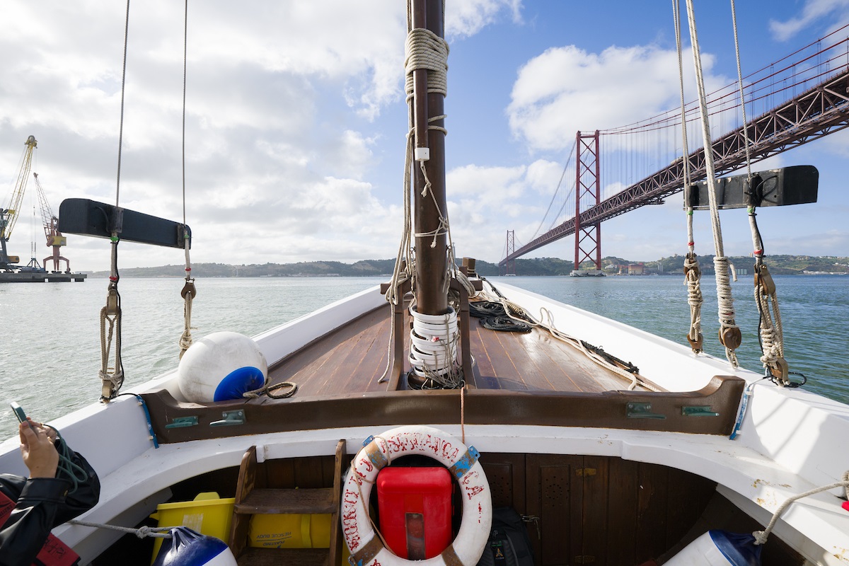 frente de um barco a navegar no rio Tejo